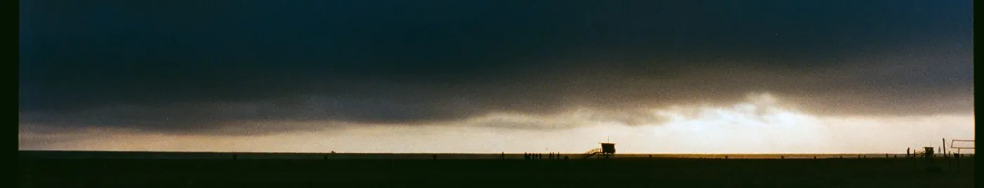 storm light over the beach, lifeguard tower on the horizon