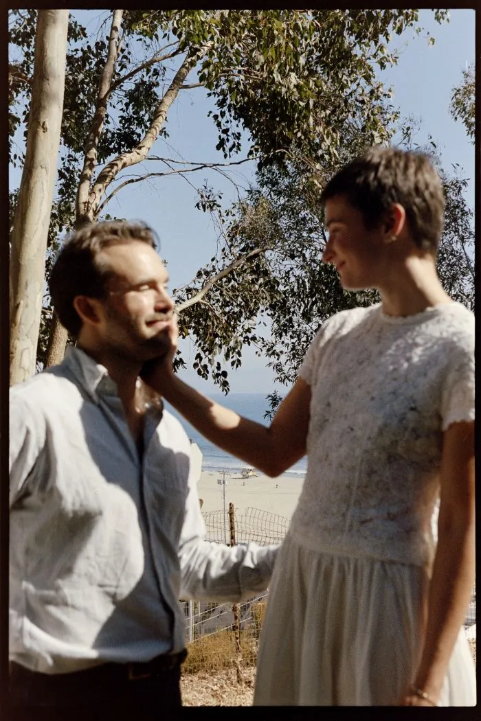 Celia holding Ian&rsquo;s cheek under a eucalyptus